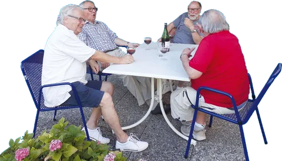 Eine Runde sitzt im Garten an einem Tisch beisammen