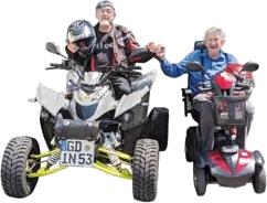 Ein Bewohner auf einem Quad neben einer Bewohnerin auf einem Elektromobil