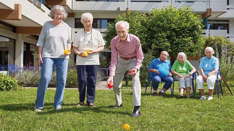 Bewohnerinnen und Bewohner spielen Boccia im Garten